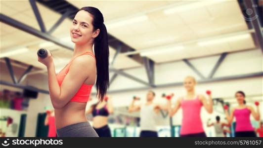 sport, exercising and healthcare concept - young sporty woman with light dumbbells