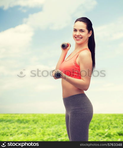 sport, exercising and healthcare concept - young sporty woman with light dumbbells