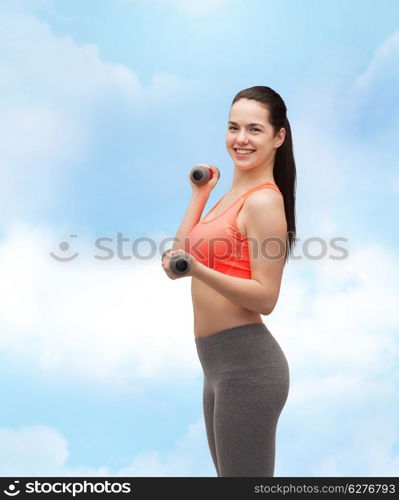 sport, exercising and healthcare concept - young sporty woman with light dumbbells