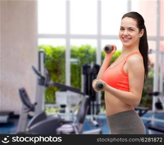 sport, exercising and healthcare concept - young sporty woman with light dumbbells