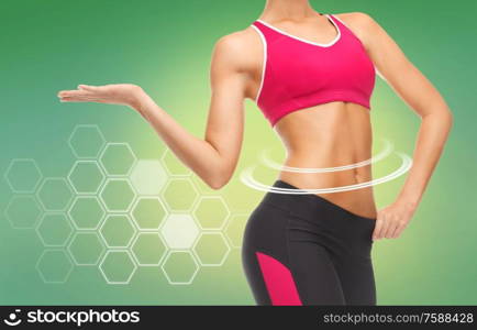 sport, fitness and diet concept - close up of slim fit woman&rsquo;s body with trained abs over green background. close up of slim fit woman&rsquo;s body with trained abs