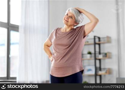 sport, fitness and healthy lifestyle concept - smiling senior woman exercising at home. smiling senior woman exercising at home