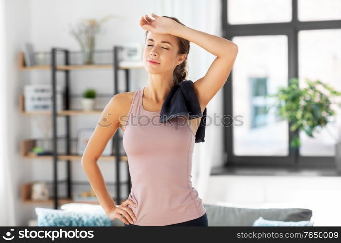 sport, fitness and healthy lifestyle concept - tired young woman with towel at home. tired young woman with towel after fitness at home