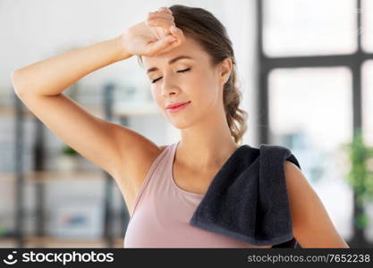 sport, fitness and healthy lifestyle concept - tired young woman with towel at home. tired young woman with towel after fitness at home