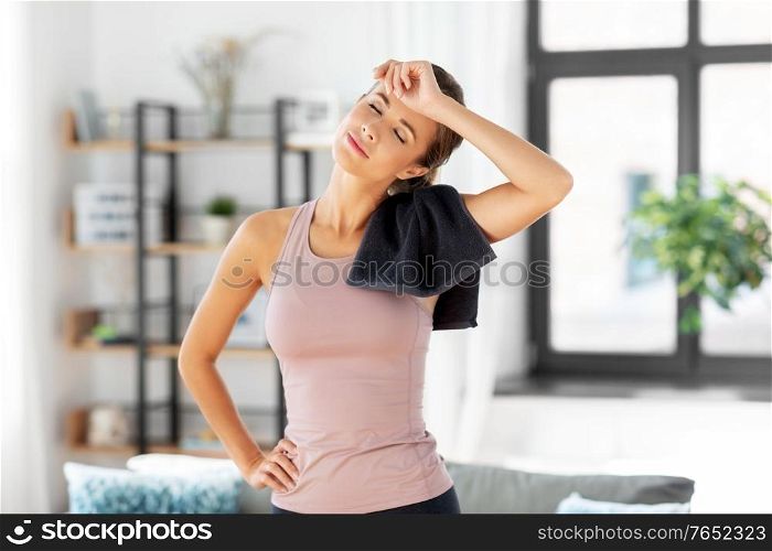 sport, fitness and healthy lifestyle concept - tired young woman with towel at home. tired young woman with towel after fitness at home