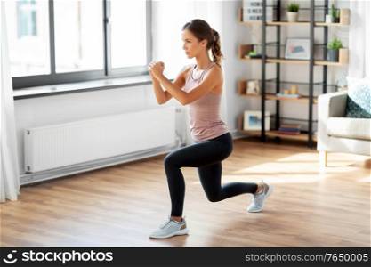 sport, fitness and healthy lifestyle concept - young woman exercising at home. young woman exercising at home
