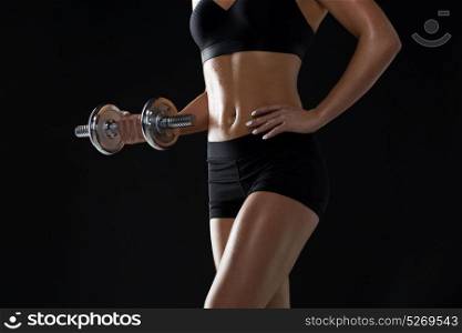 sport, fitness and people concept - close up of young sporty woman exercising with dumbbell. close up of sporty woman exercising with dumbbell
