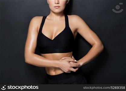 sport, fitness and people concept - close up of young woman in black sportswear posing in gym. close up of woman in black sportswear posing