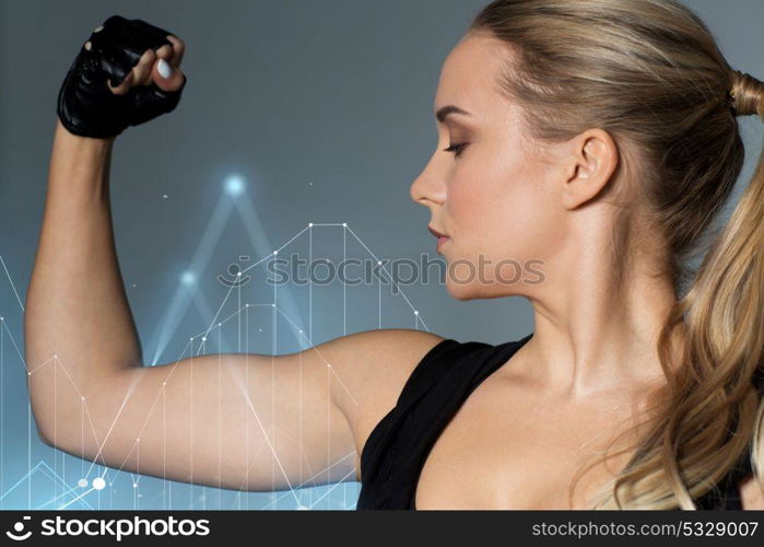 sport, fitness and people concept - close up of young woman posing and showing muscles over gray background with diagram chart hologram. close up of woman posing and showing biceps in gym