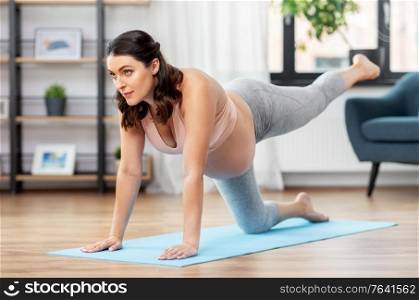 sport, fitness and people concept - happy pregnant woman exercising at home. happy pregnant woman doing sports at home