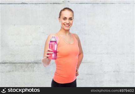 sport, fitness and people concept - happy sportive woman with water bottle over concrete wall background. happy sportive young woman with water bottle