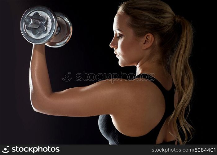 sport, fitness and people concept - young sporty woman exercising with dumbbell. young sporty woman exercising with dumbbell. young sporty woman exercising with dumbbell
