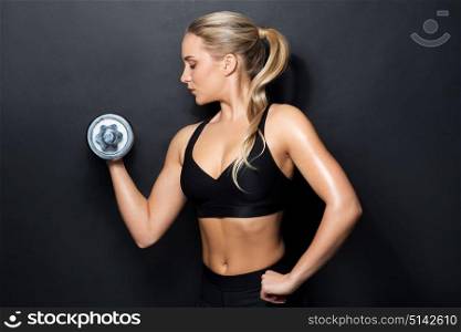 sport, fitness and people concept - young sporty woman exercising with dumbbell. young sporty woman exercising with dumbbell