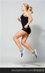 sport, fitness and people concept - young woman in black sportswear jumping in gym. young woman in black sportswear jumping
