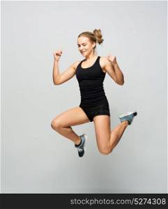 sport, fitness and people concept - young woman in black sportswear jumping in gym. young woman in black sportswear jumping