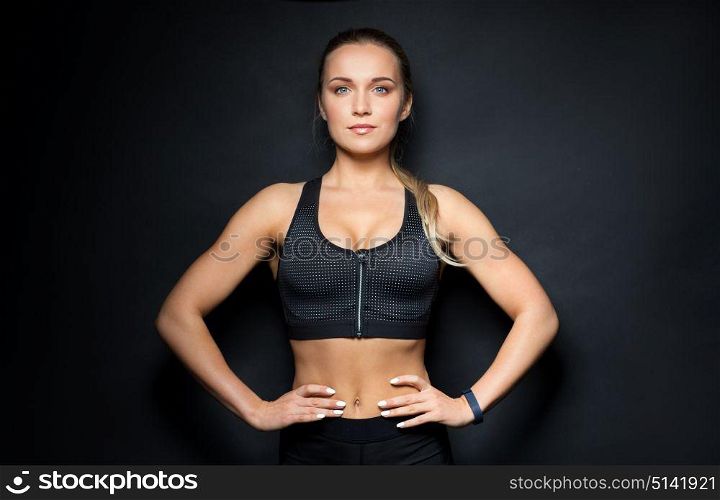 sport, fitness and people concept - young woman in black sportswear posing in gym. young woman in black sportswear posing