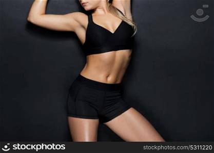 sport, fitness and people concept - young woman in black sportswear posing in gym. young woman in black sportswear posing