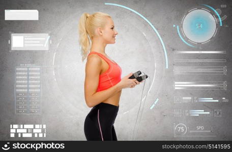 sport, fitness and people - happy sporty woman with skipping rope over gray concrete background. sporty woman with skipping rope