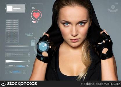 sport, fitness and technology concept - close up of young woman in black sportswear posing in gym. close up of woman in black sportswear