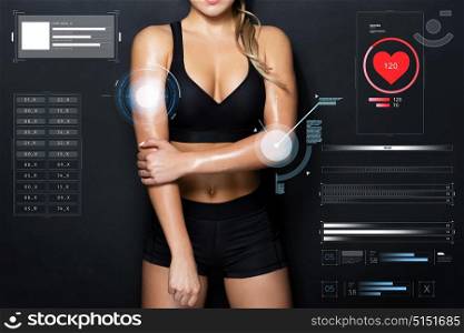 sport, fitness and technology concept - close up of young woman in black sportswear posing in gym. close up of woman in black sportswear posing