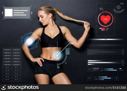 sport, fitness and technology concept - young woman in black sportswear posing in gym. young woman in black sportswear posing