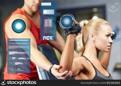 sport, fitness, bodybuilding and people concept - man and woman with dumbbells flexing muscles in gym over virtual charts. man and woman with dumbbells in gym