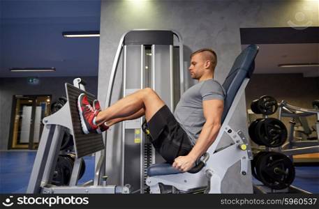 sport, fitness, bodybuilding, lifestyle and people concept - man exercising and flexing leg muscles on gym machine
