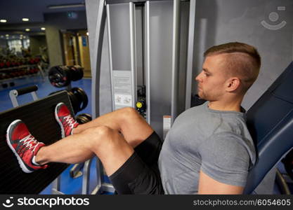 sport, fitness, bodybuilding, lifestyle and people concept - man exercising and flexing leg muscles on gym machine