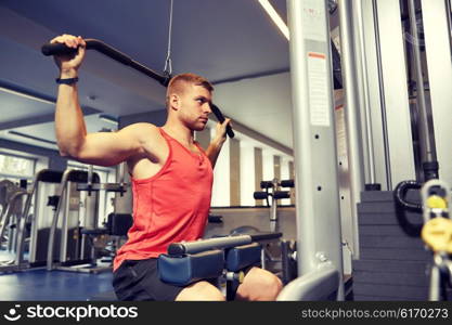 sport, fitness, bodybuilding, lifestyle and people concept - man exercising and flexing muscles on cable machine in gym