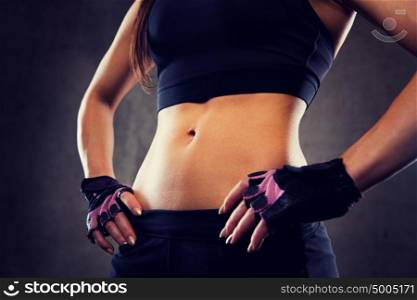 sport, fitness, bodybuilding, sportswear and people concept - close up of young woman body in gym. close up of young woman body in gym