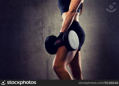 sport, fitness, bodybuilding, weightlifting and people concept - close up of woman with dumbbell in gym. close up of woman with dumbbell in gym