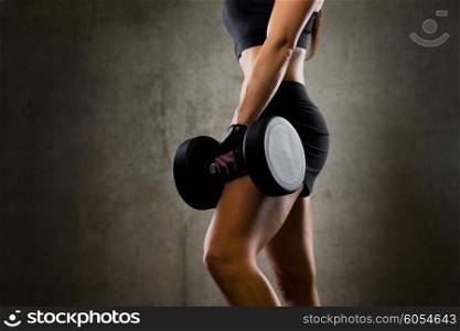 sport, fitness, bodybuilding, weightlifting and people concept - close up of woman with dumbbell in gym
