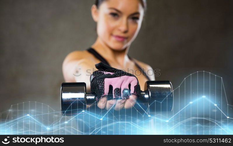 sport, fitness, bodybuilding, weightlifting and people concept - woman holding dumbbell in gym. woman holding dumbbell in gym