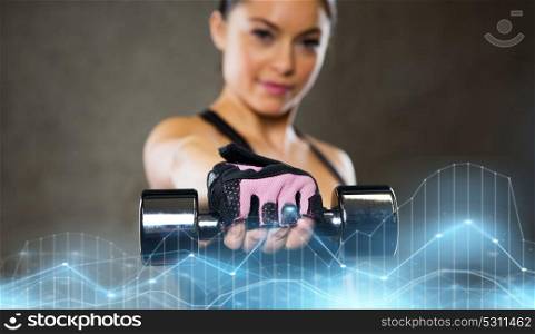 sport, fitness, bodybuilding, weightlifting and people concept - woman holding dumbbell in gym. woman holding dumbbell in gym