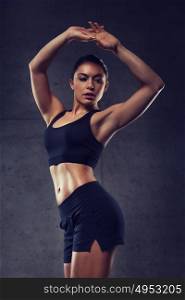 sport, fitness, bodybuilding, weightlifting and people concept - young woman posing and showing muscles in gym. young woman posing and showing muscles in gym