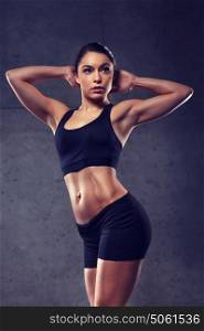 sport, fitness, bodybuilding, weightlifting and people concept - young woman posing and showing muscles in gym. young woman posing and showing muscles in gym