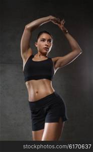 sport, fitness, bodybuilding, weightlifting and people concept - young woman posing and showing muscles in gym