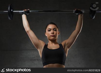 sport, fitness, bodybuilding, weightlifting and people concept - young woman with barbell flexing muscles in gym