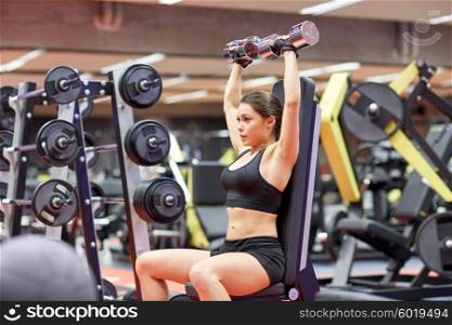 sport, fitness, bodybuilding, weightlifting and people concept - young woman with dumbbell flexing muscles in gym from back