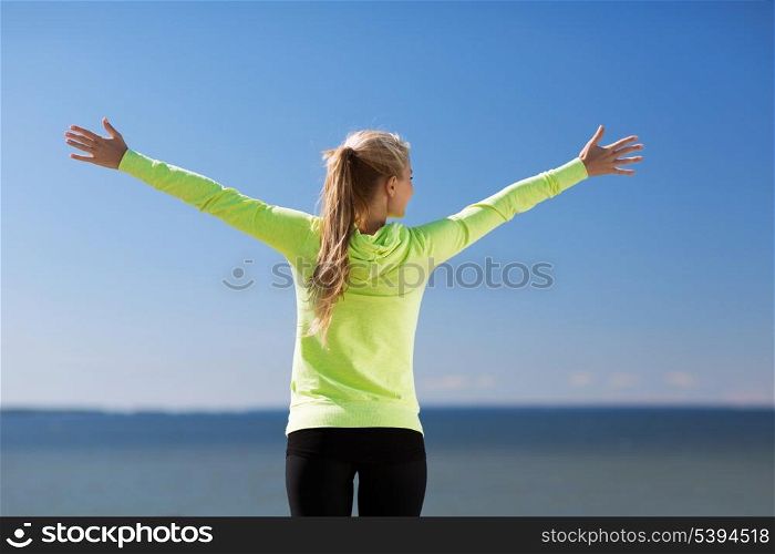 sport, fitness, exercise and lifestyle concept - woman doing sports outdoors