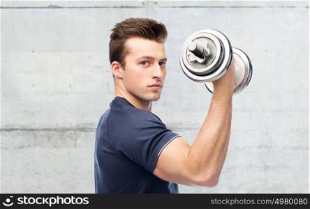 sport, fitness, exercising, bodybuilding and people concept - happy sportive man with dumbbell flexing muscles over concrete wall background. sportive man flexing muscles with dumbbell
