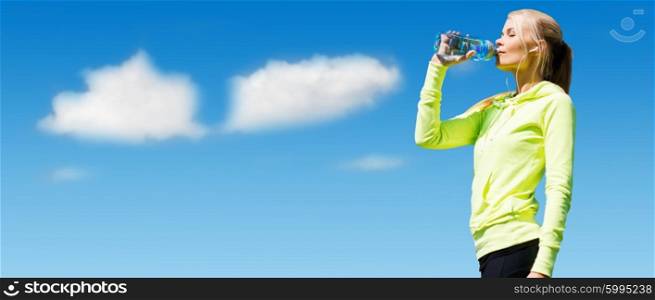 sport, fitness, exercising, people and lifestyle concept - woman drinking water after doing sports outdoors over blue sky and clouds background