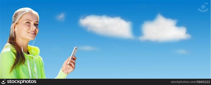 sport, fitness, exercising, technology and people - sporty woman with smartphone and earphones listening to music over blue sky and clouds background