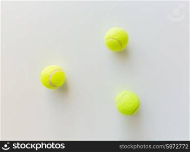 sport, fitness, game and objects concept - close up of three yellow tennis balls