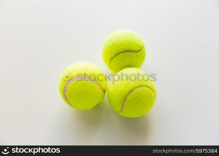 sport, fitness, game and objects concept - close up of three yellow tennis balls