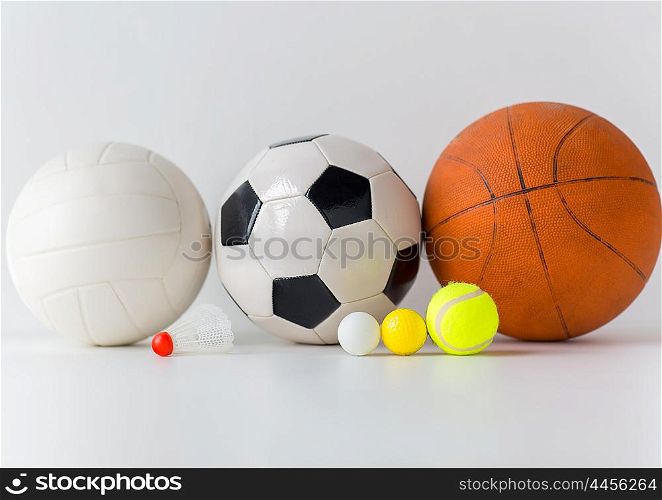 sport, fitness, game, sports equipment and objects concept - close up of different sports balls and shuttlecock