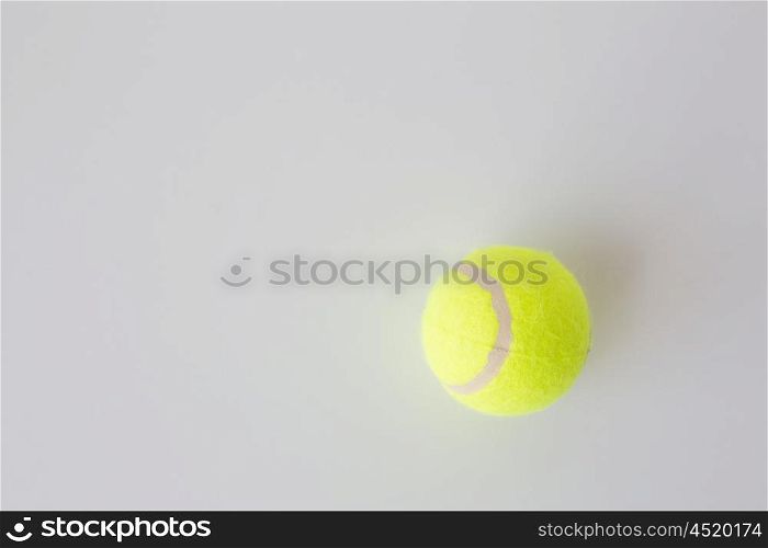 sport, fitness, game, sports equipment and objects concept - close up of tennis ball over white background from top