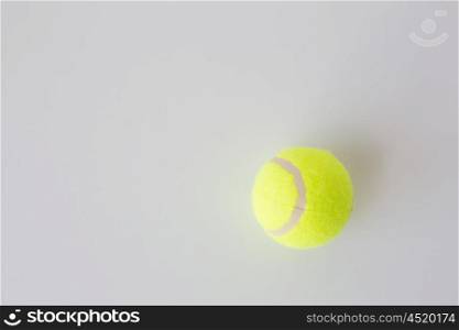 sport, fitness, game, sports equipment and objects concept - close up of tennis ball over white background from top