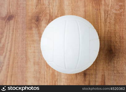 sport, fitness, game, sports equipment and objects concept - close up of volleyball ball on wooden floor from top