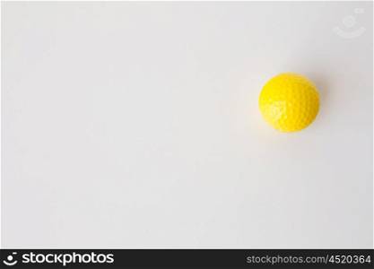 sport, fitness, game, sports equipment and objects concept - close up of yellow golf ball over white background from top